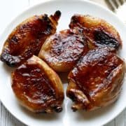 Caramelized shallots are served on a white plate.