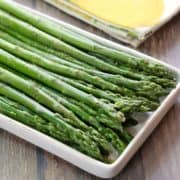 Steamed asparagus is served on a serving platter.