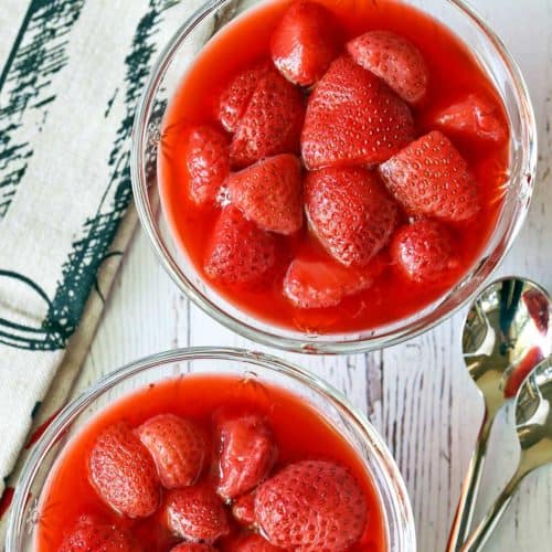 Strawberry compote is served in dessert glasses with spoons.
