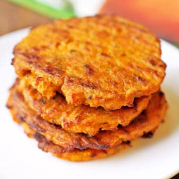 Sweet potato cakes are stacked on a white plate.