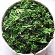 Sauteed kale is served in a white bowl.