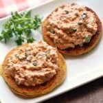 Salmon salad is served on bread slices with parsley for garnish.