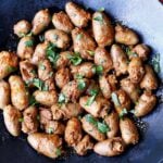 Chicken hearts are served on a dark plate.