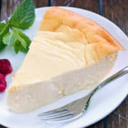 Ricotta cheesecake is served on a white plate with a fork.