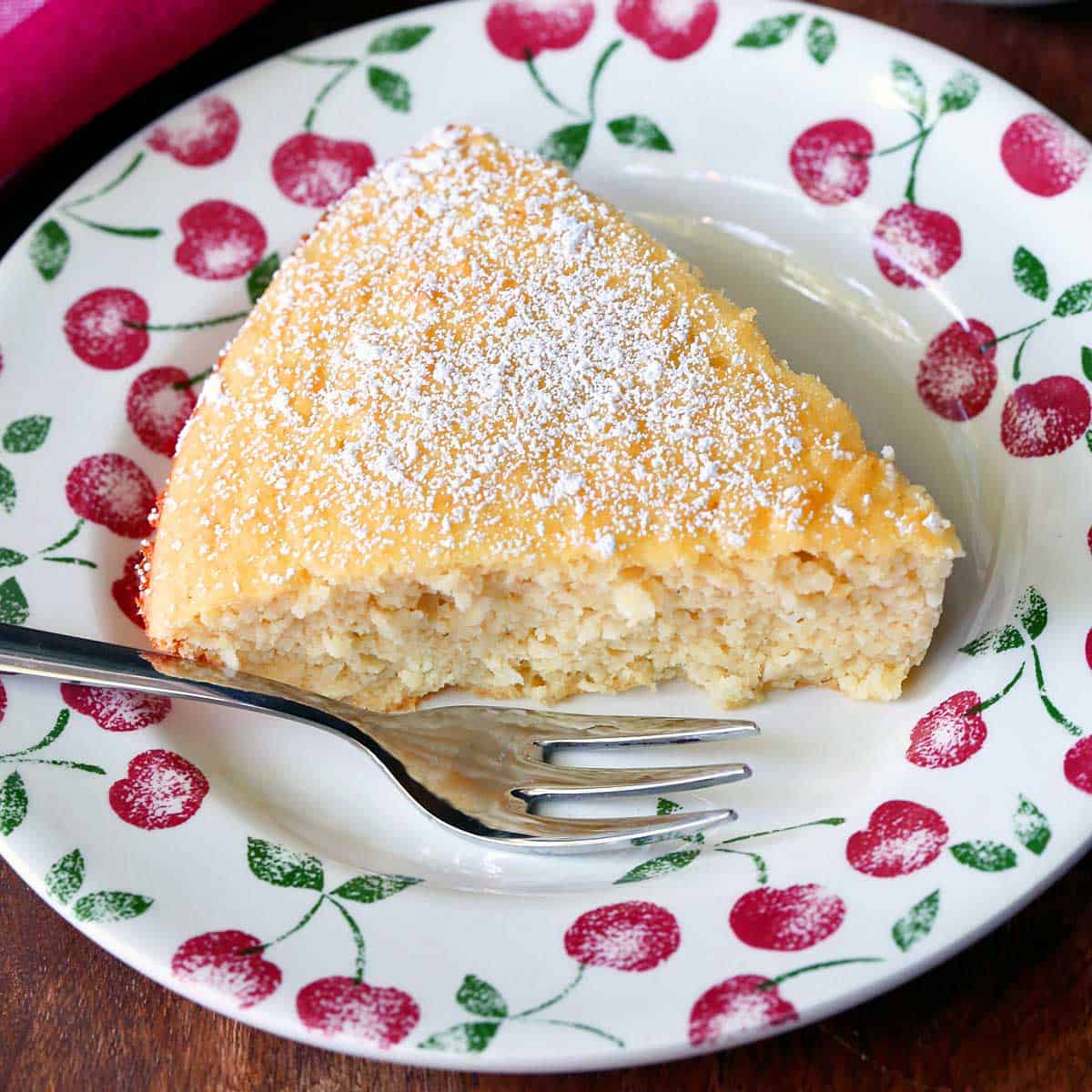 Keto coconut cake is served on a plate with a fork.