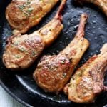 Lamb chops are served in a cast-iron skillet.