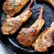 Lamb chops are served in a cast-iron skillet.