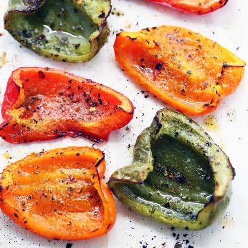 Roasted peppers are served on a white plate.