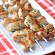 Oven chicken kabobs are served on a white platter.