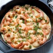 Shrimp in cream sauce is served in a cast-iron skillet.