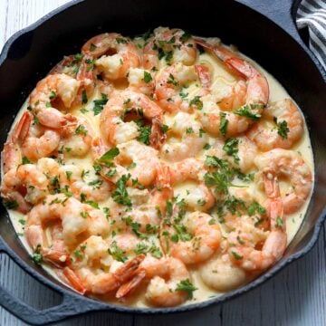 Shrimp in cream sauce is served in a cast-iron skillet.