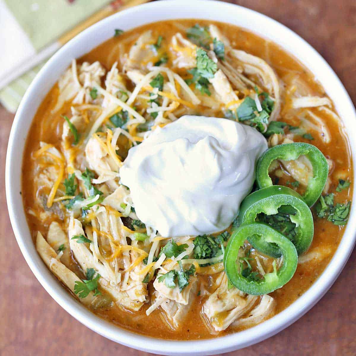 Chicken chili is topped with sour cream.