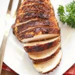 Blackened chicken, sliced, is served with a fork.