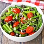 Asparagus salad is served in a white bowl with a napkin.