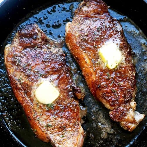 New York strip steak in a cast-iron skillet.