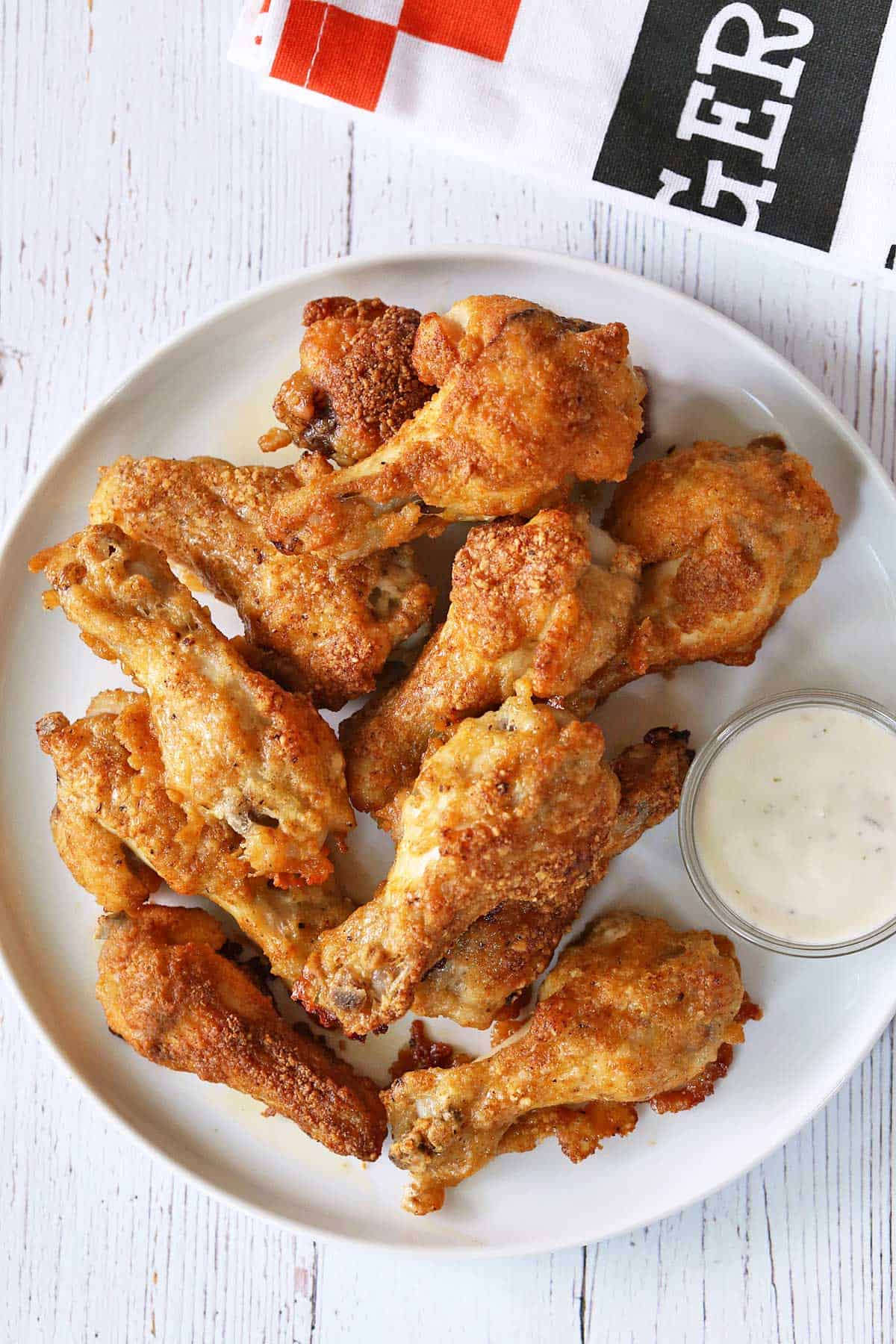Garlic parmesan wings are served with a dipping sauce. 