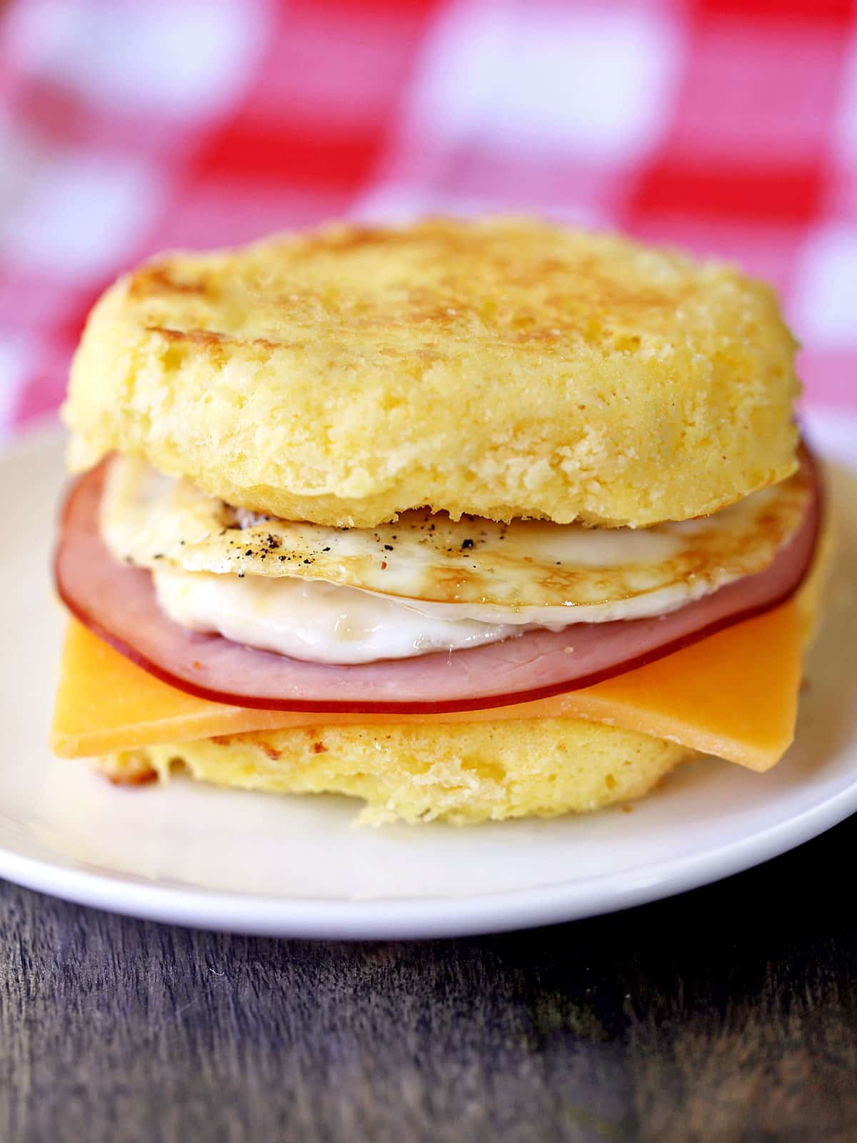 Keto breakfast sandwich is served on a white plate.