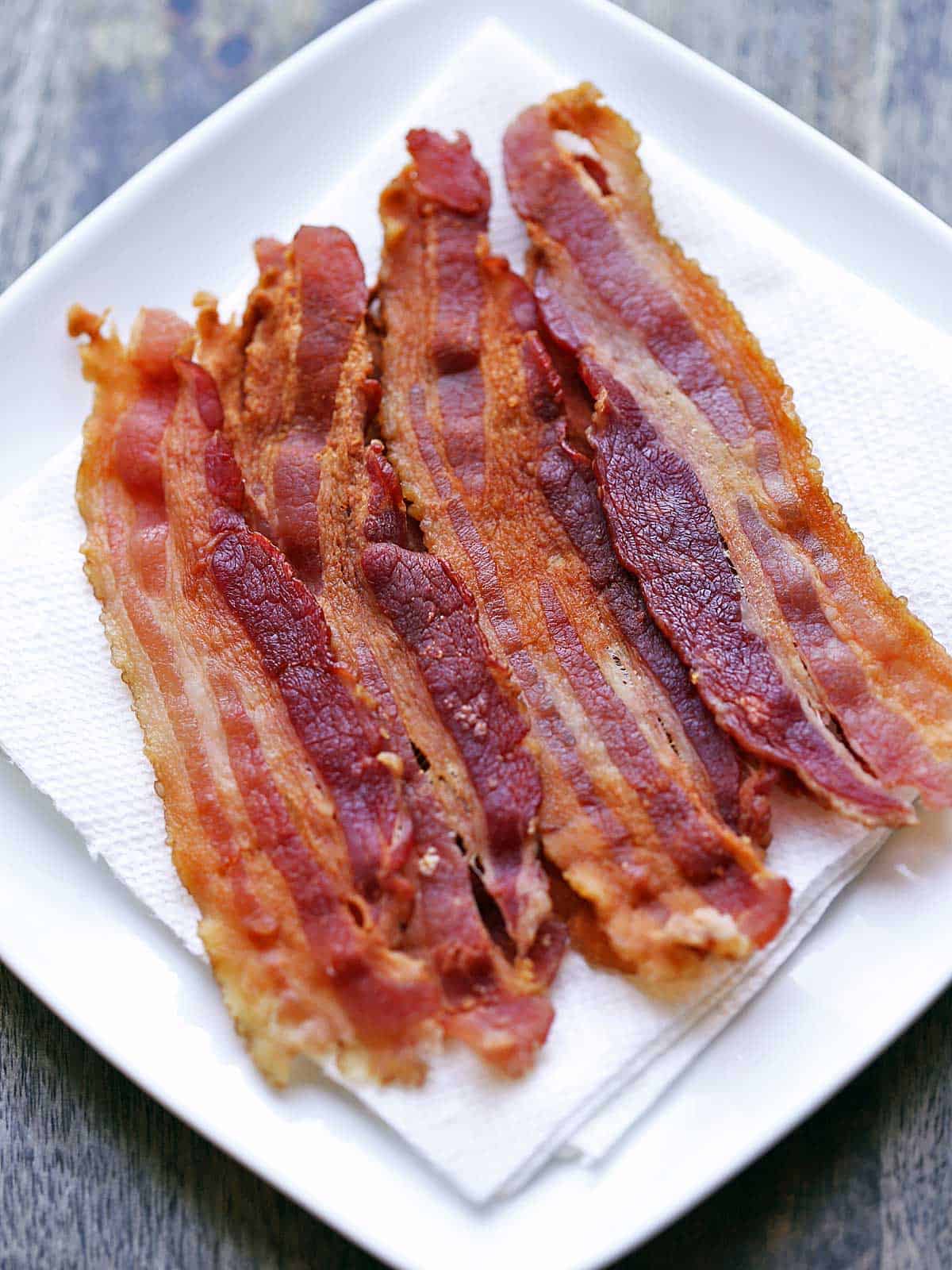 Strips of microwave bacon are served on a paper-towel-lined plate. 