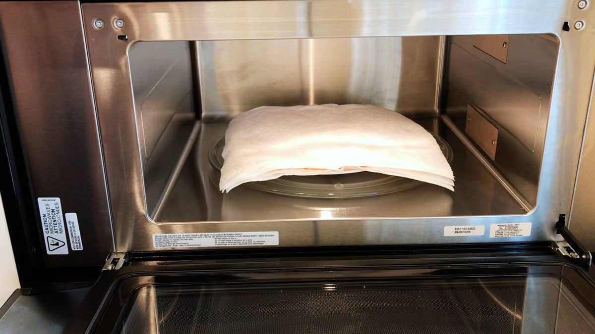 Placing the bacon in the microwave.