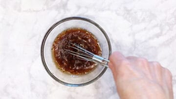 Mixing the dressing in a bowl.