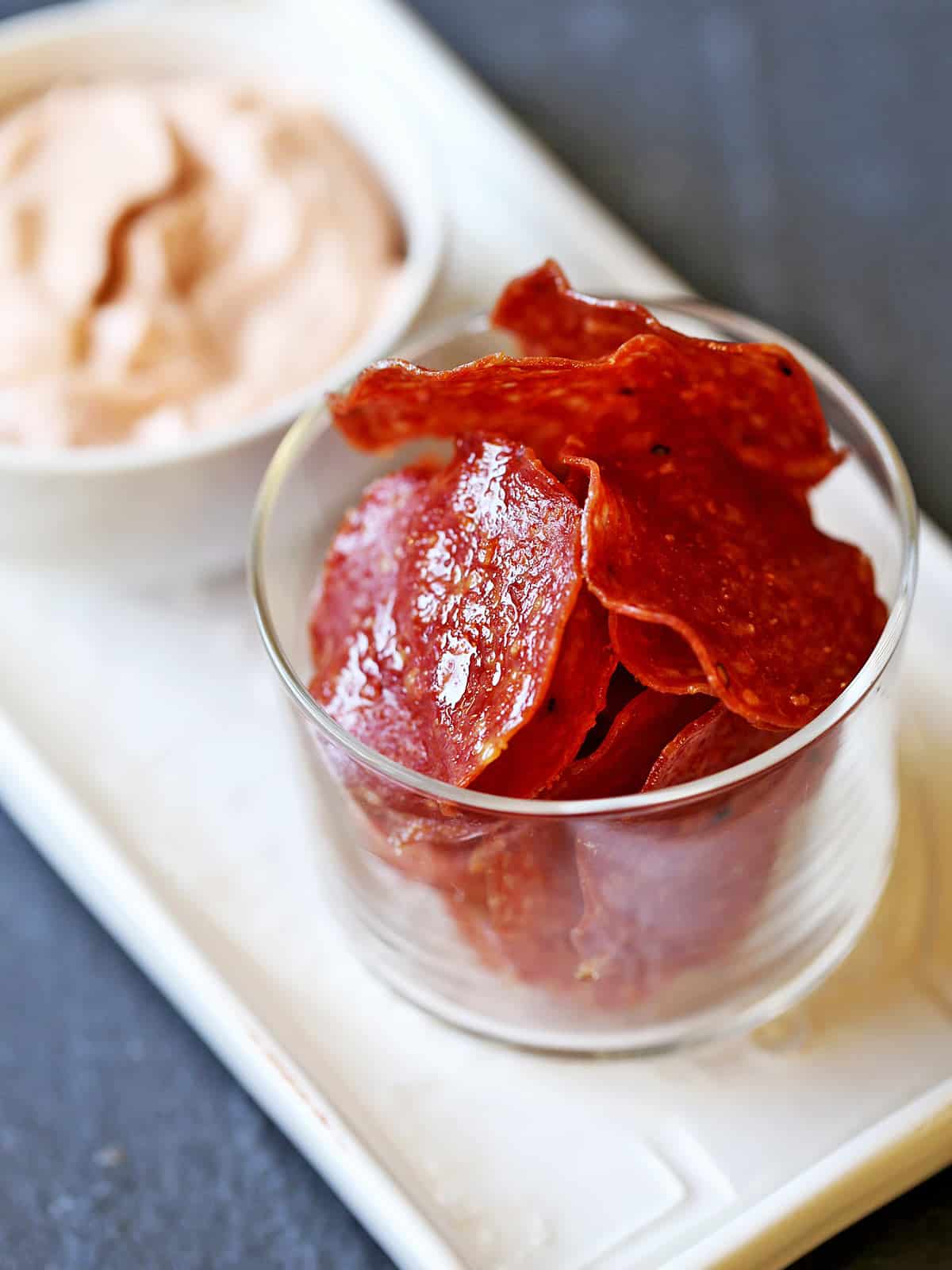 Salami chips are served with a spicy dip. 