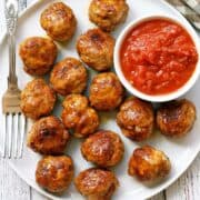 Chicken meatballs are served with a dipping sauce.