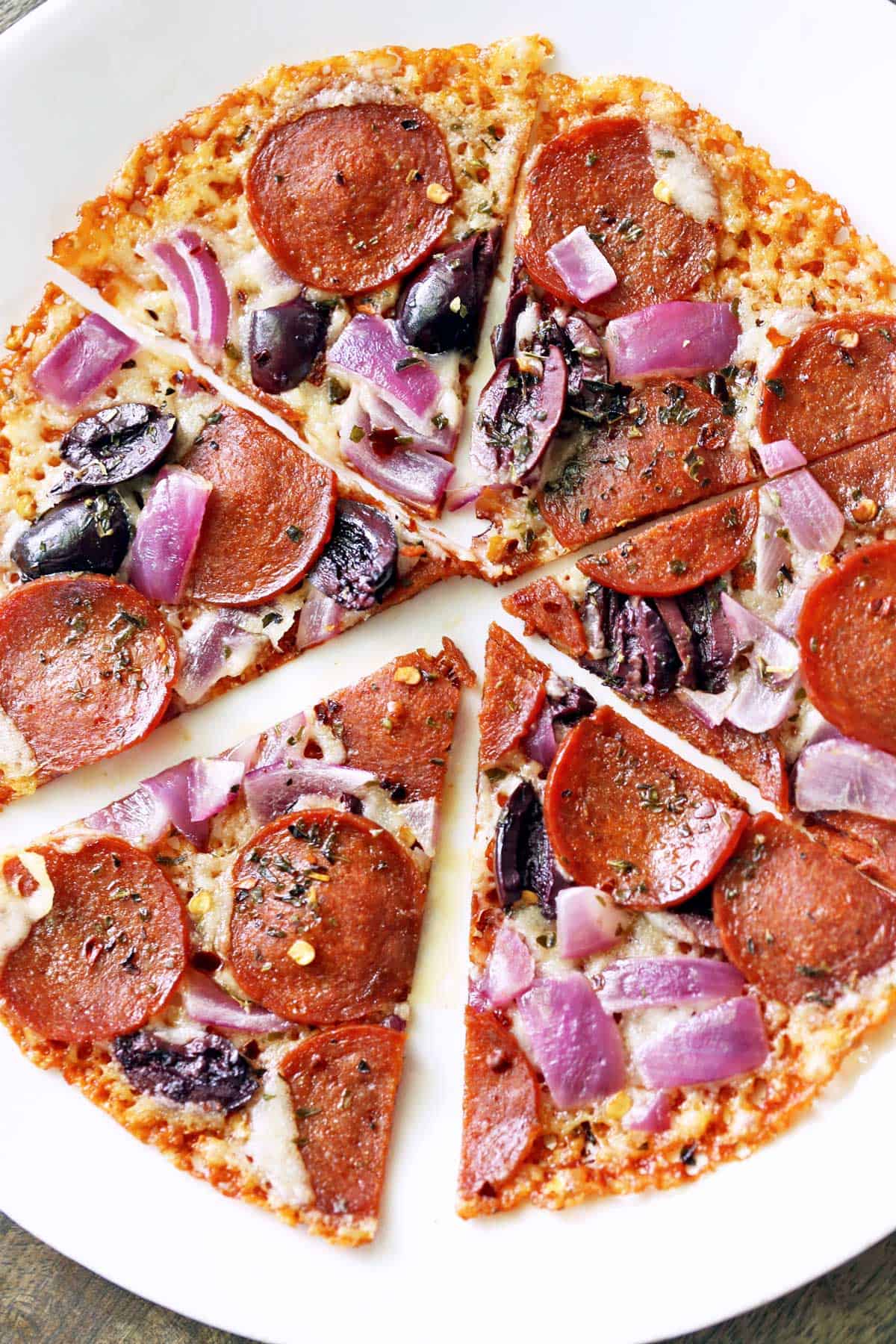 Crustless pizza is served on a white plate. 