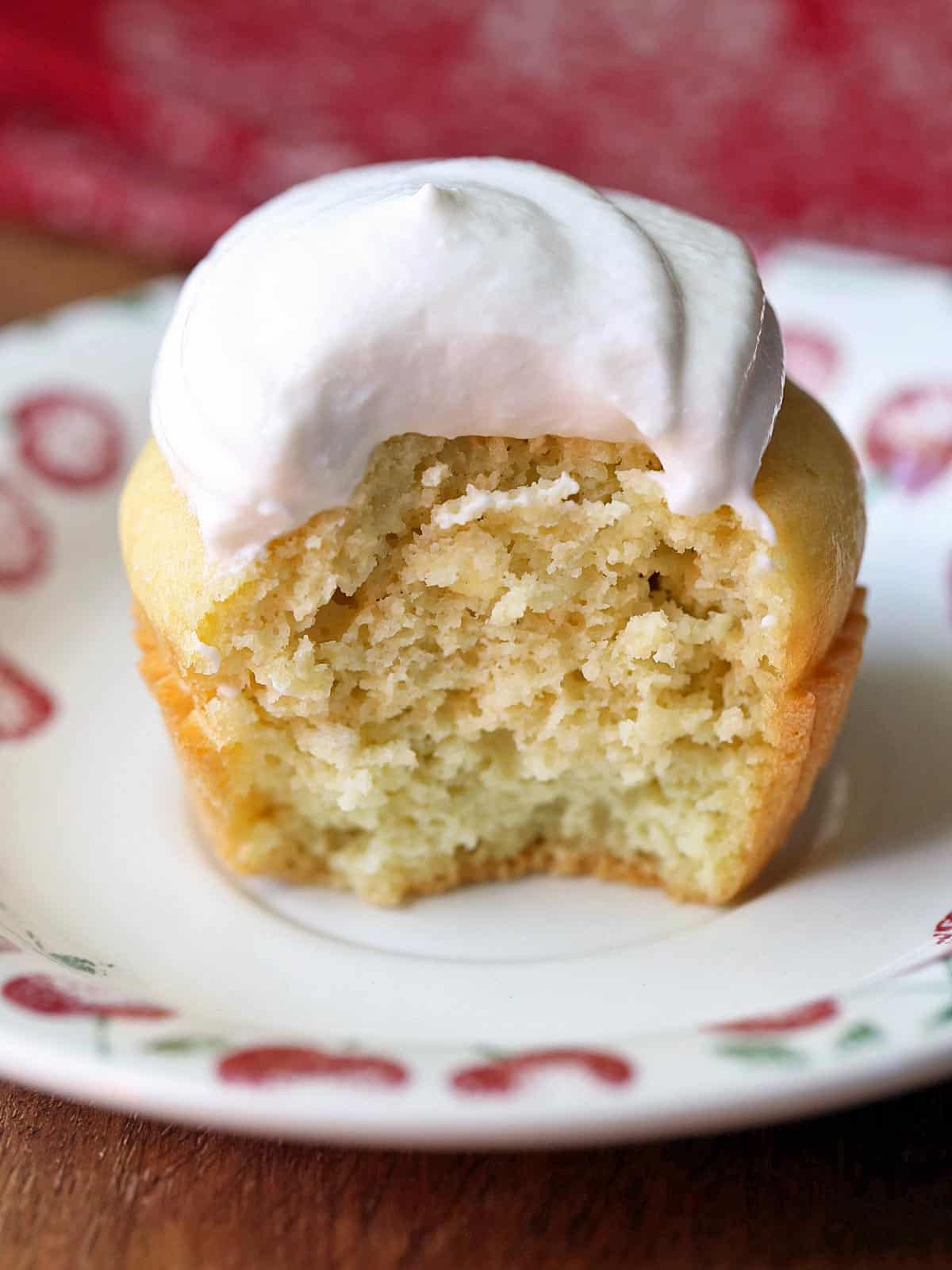 A yellow cupcake topped with Greek yogurt frosting. 