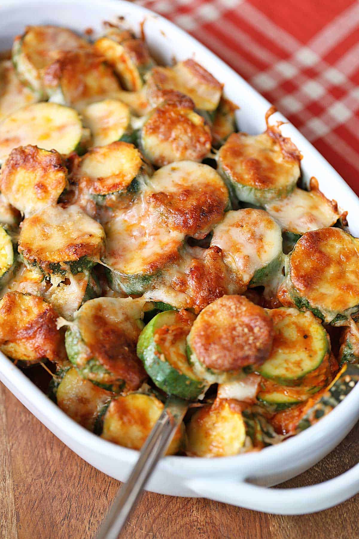Zucchini casserole is served in a white baking dish. 