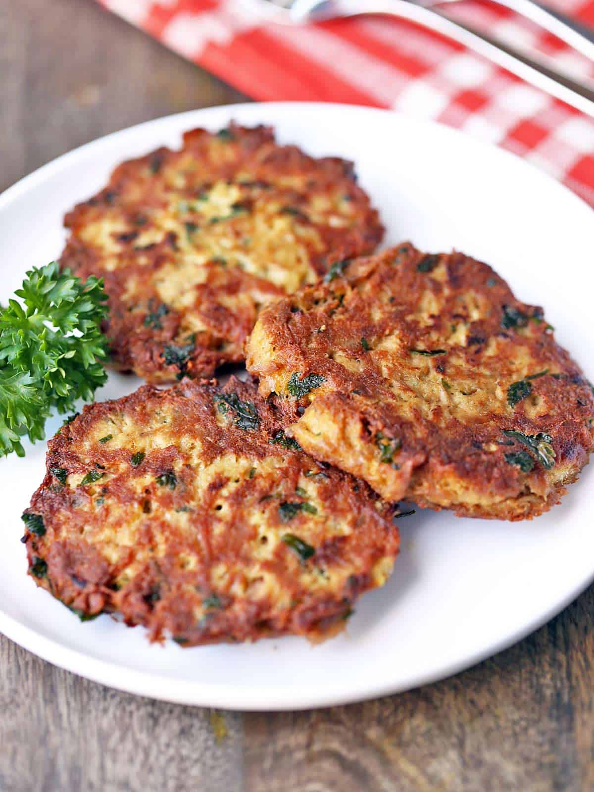 Three tuna patties are served on a white plate.