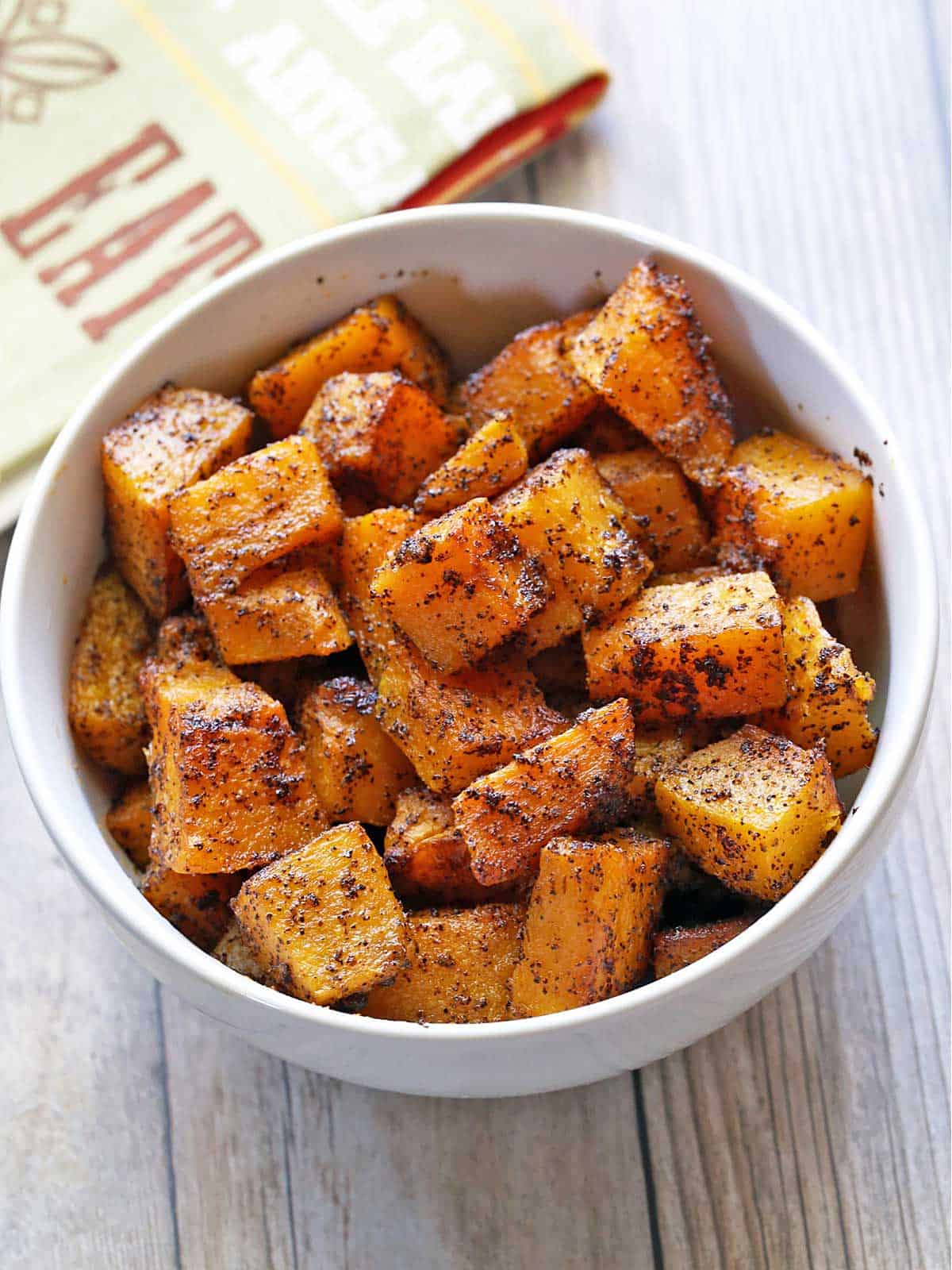 Roasted butternut squash is served in a bowl with a napkin. 