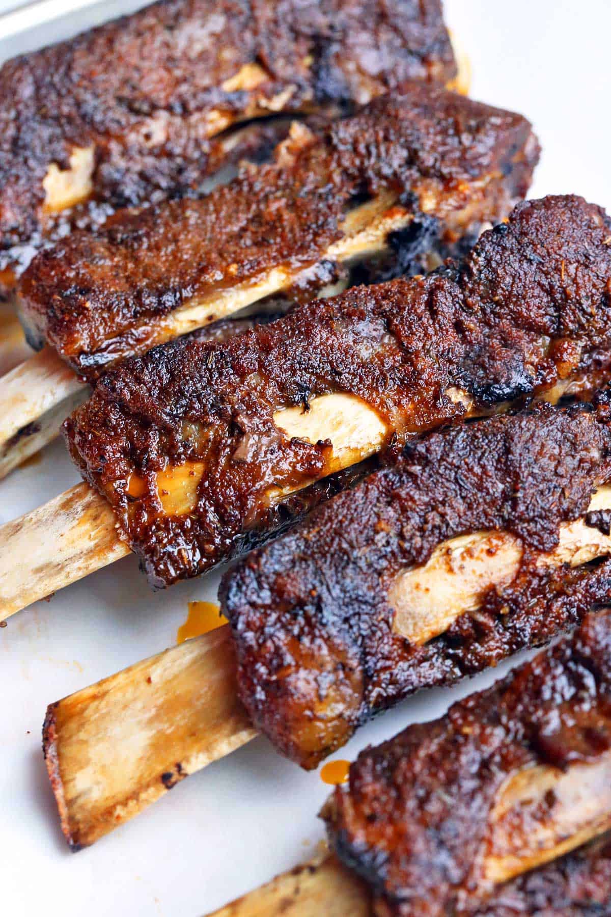 Slow cooker beef ribs are served on a baking sheet. 