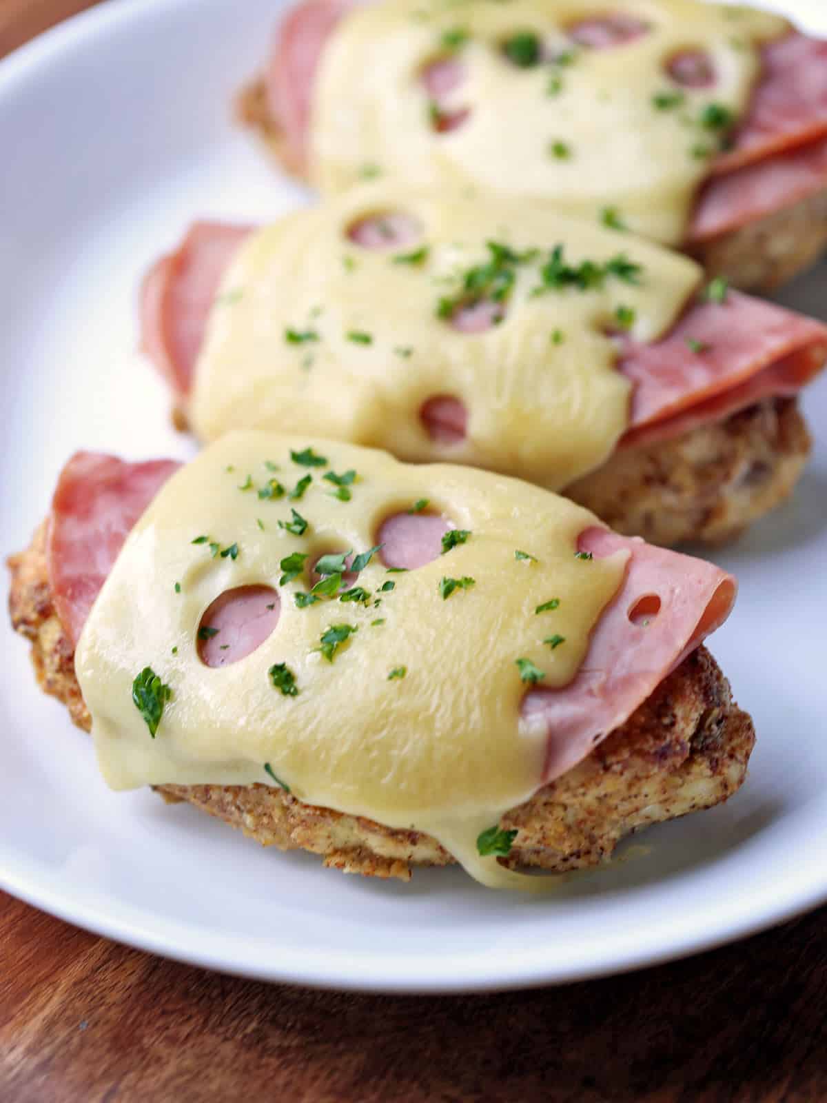 Three pieces of keto Chicken Cordon Bleu are served on a white plate.