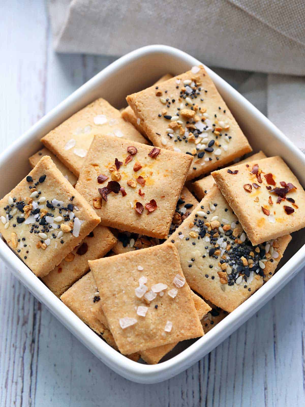 Almond flour crackers are served in a white bowl with a napkin. 