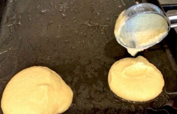 Adding the pancake batter to the griddle.