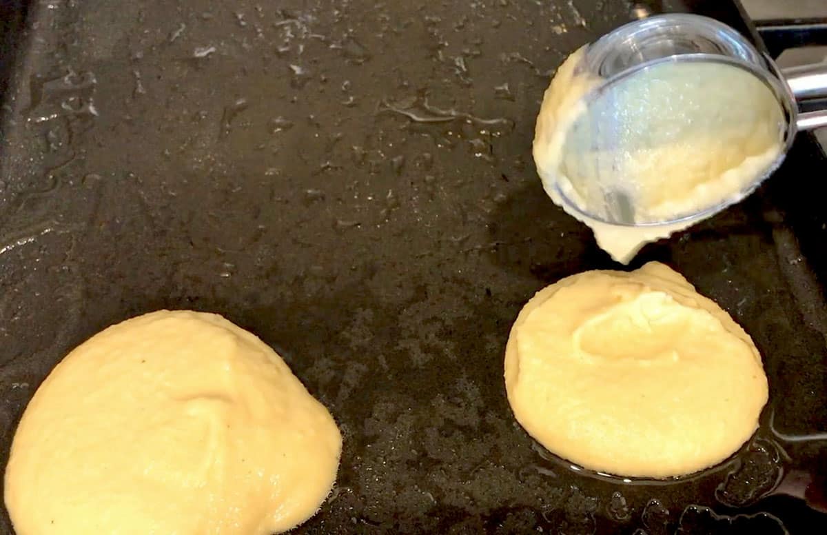 Adding the pancake batter to the griddle.