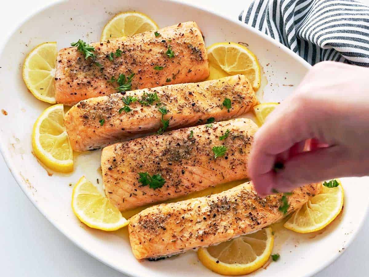 Garnishing baked salmon with parsley.