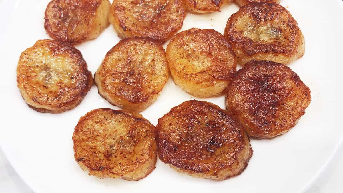 Fried bananas served on a white plate.