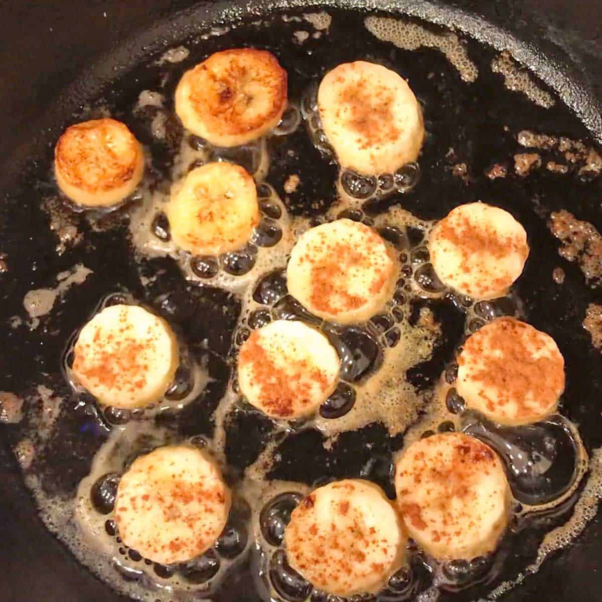 Banana slices cooking in a skillet.