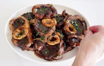 Garnishing beef shanks with parsley.