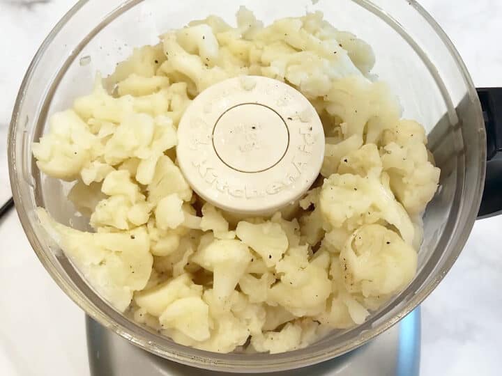 Adding the cauliflower to the food processor.