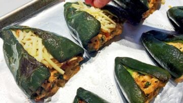 Sprinkling the poblano peppers with cheese.