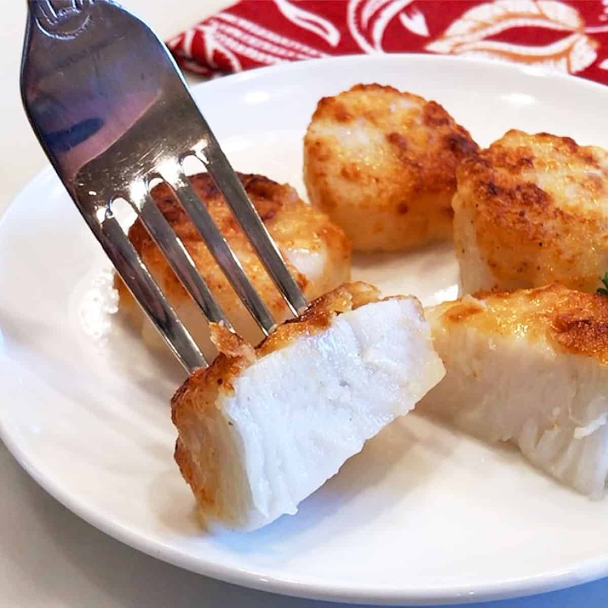 A halved scallop with a white, moist center.
