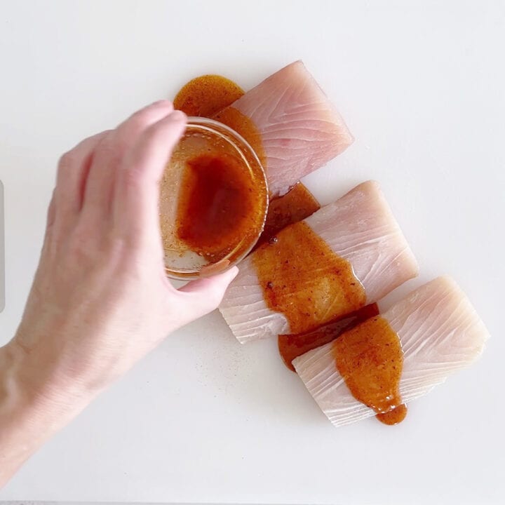 Coating mahi mahi with marinade.