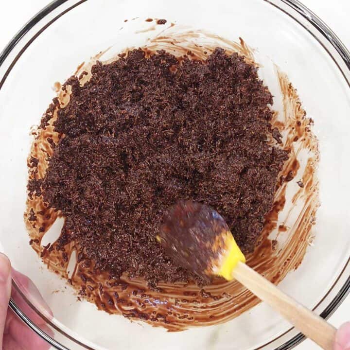 Mixing shredded coconut into melted chocolate.