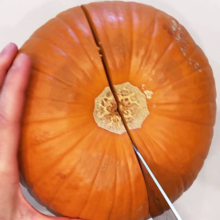 Cutting a pumpkin in half.