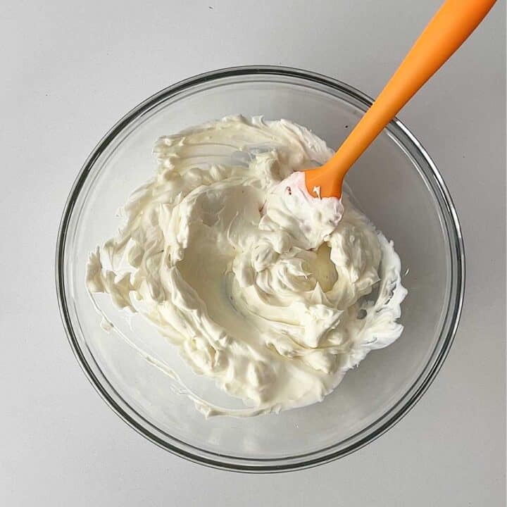 Mixing cream cheese in a bowl.
