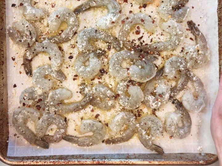 Seasoned shrimp on a baking sheet.