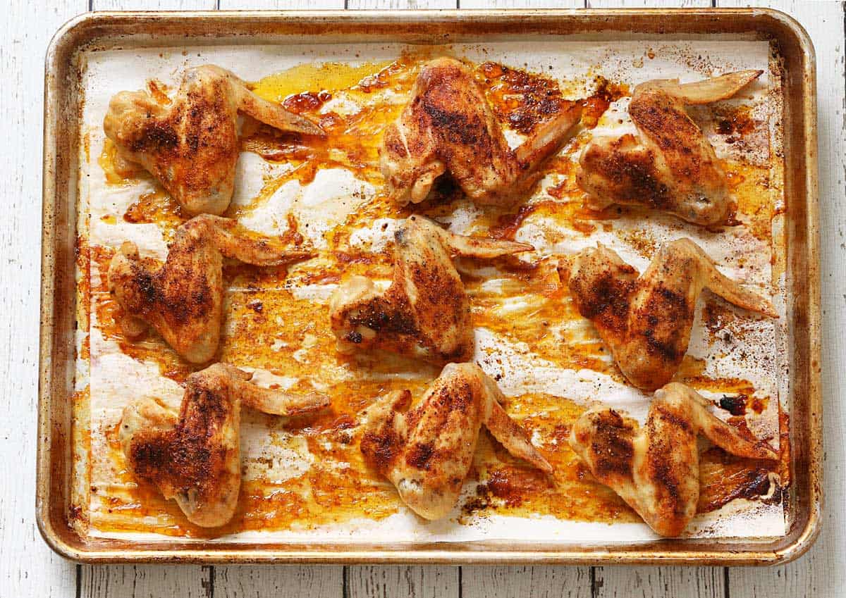 Whole chicken wings in the pan after an additional 30 minutes in a warm oven.