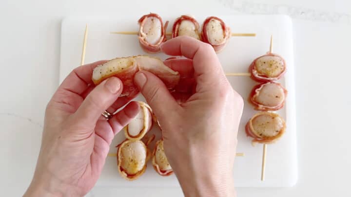 Wrapping the scallops with bacon.